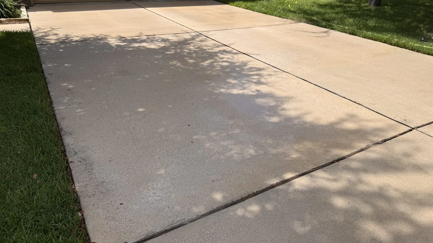 Clean concrete driveway after pressure washing by Stain Guys