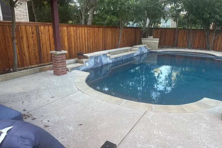 Backyard pool with a stained cedar privacy fence in Georgetown, TX
