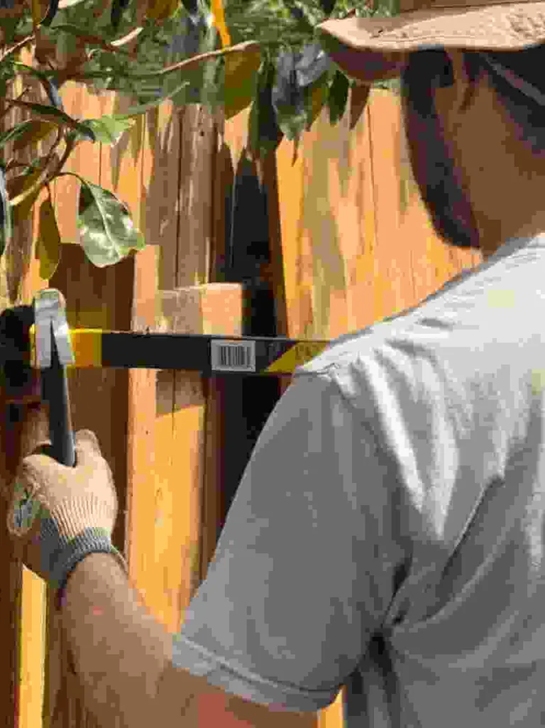 Stain Guys crew member leveling fence boards